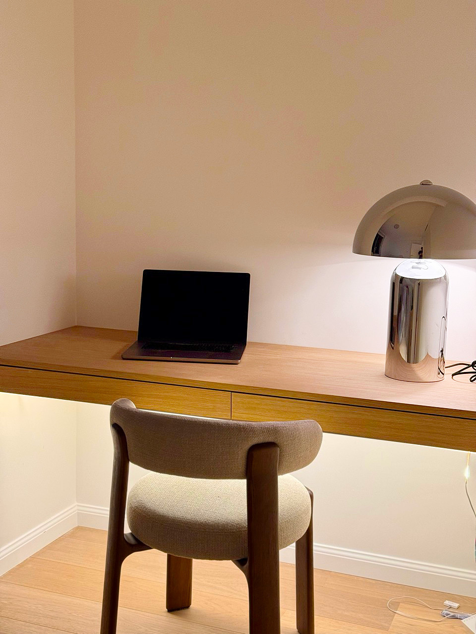 Guest room desk detail with laptop, chrome task lamp, and curated objects