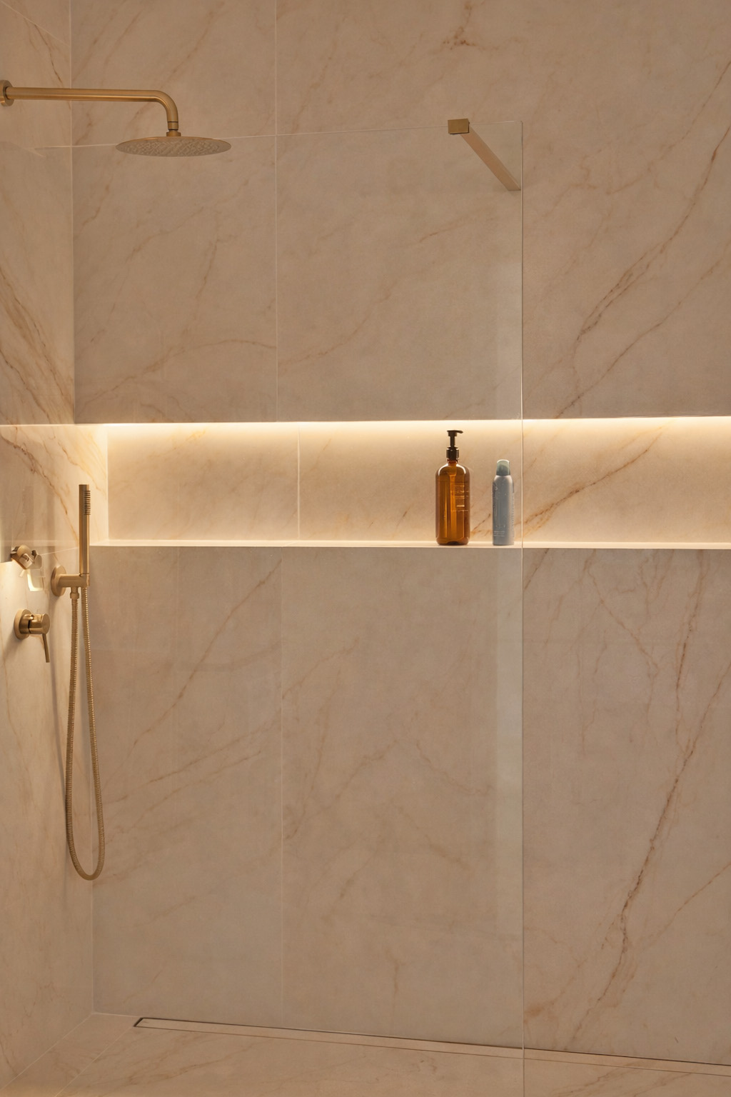 Guest bathroom with marble walls and brass rain shower