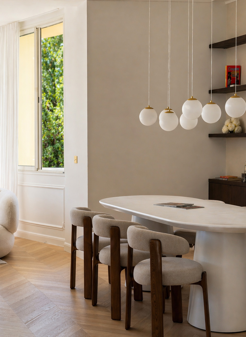 Dining area with sculptural table and view onto private garden