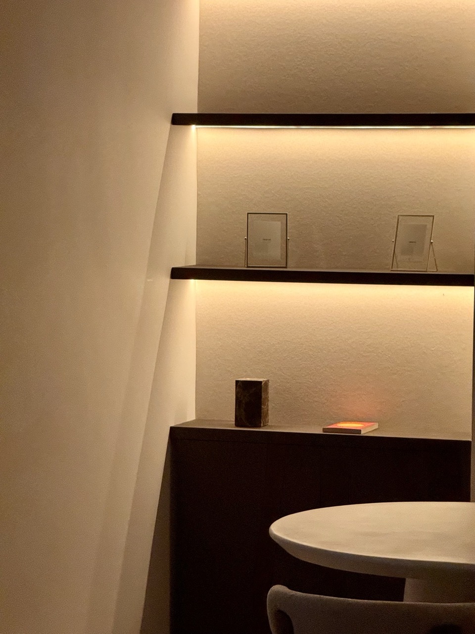 Living room corner at night with ambient backlighting and reading lamp